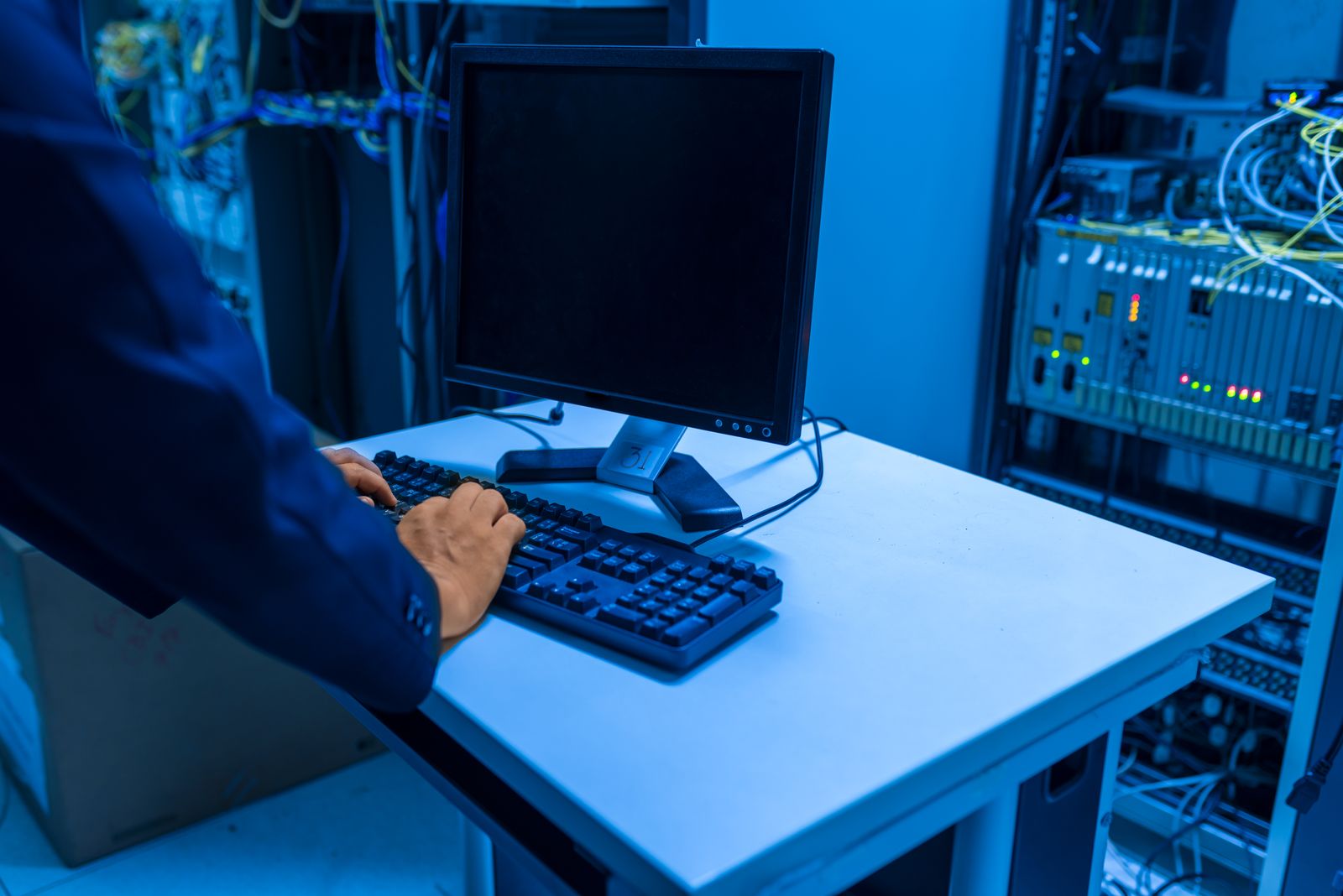 IT technician working at a computer inside a server room at EvaroTech
