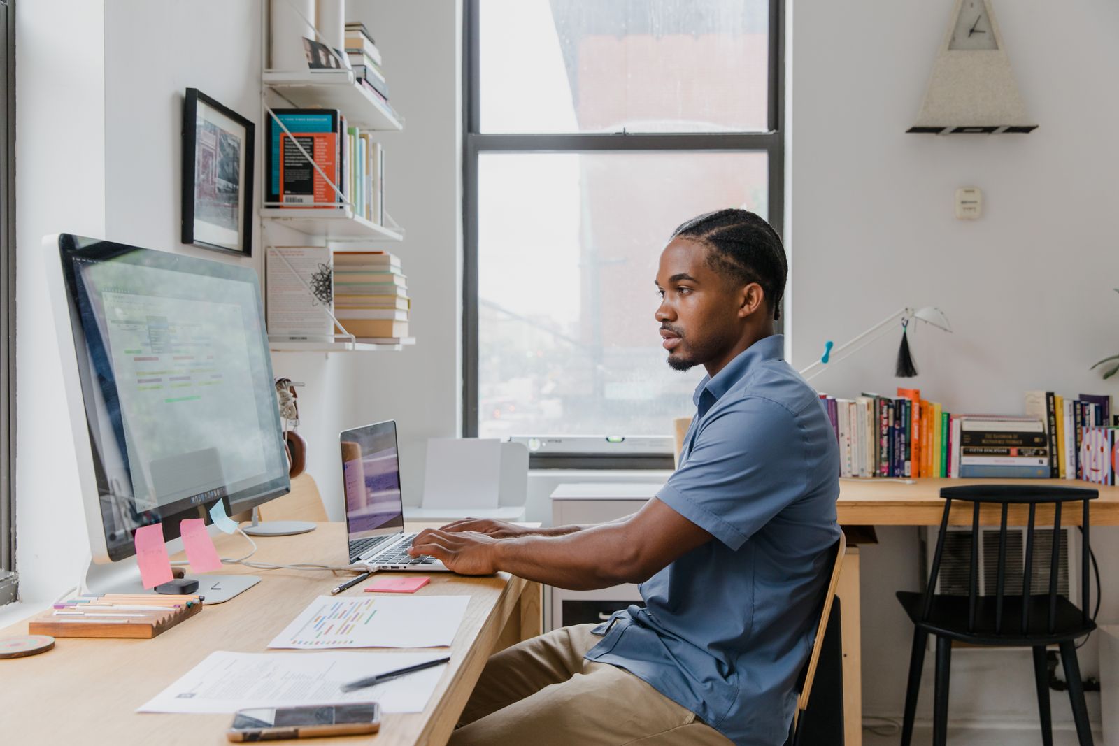 IT technician working at a desk with monitors and a laptop at EvaroTech