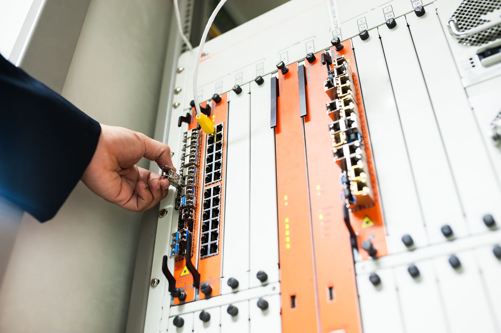 Technician installing hardware into a server rack on site