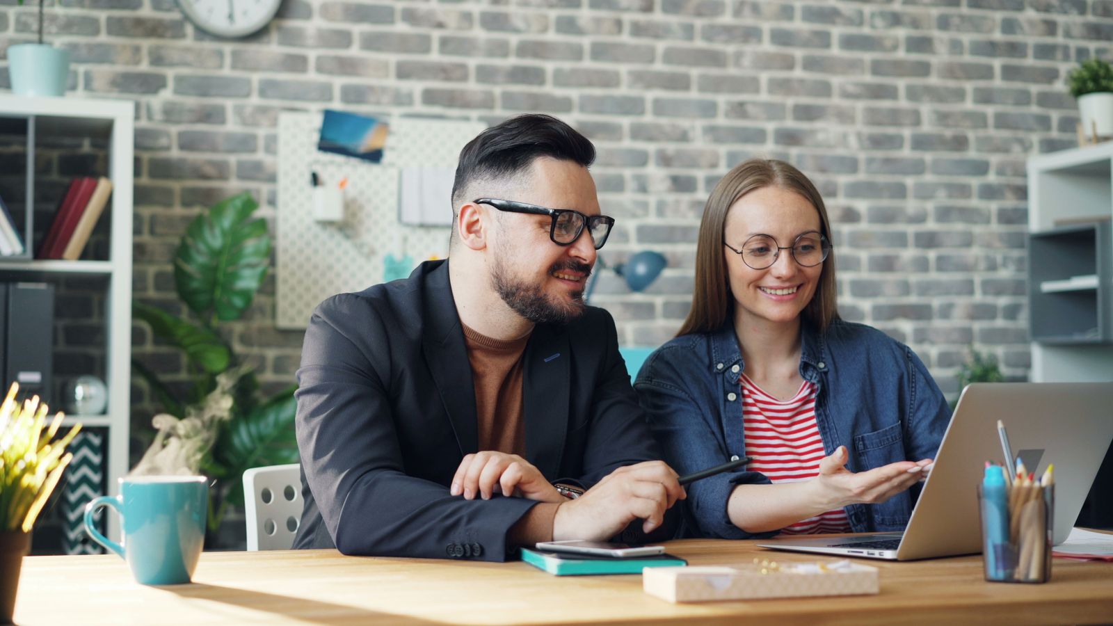 Client and consultant smiling as they review options together on a laptop